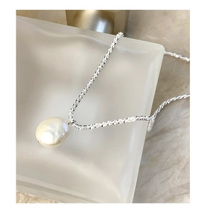 Detail of the shimmering S925 silver chain with a lustrous white baroque pearl pendant