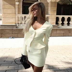 Detail of a chic cream yellow blazer and matching mini skirt set in an urban street setting