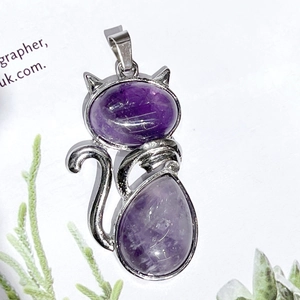 Detailed view of cat pendant with purple crystal gemstones and silver alloy frame