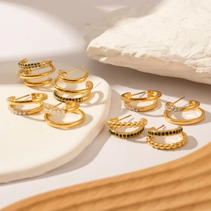 Set of four 18K gold-plated C-shaped earrings with green emeralds and pearls on stone props