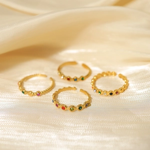 Detailed macro shot of a four-piece gold-plated ring set with colorful cubic zirconia stones