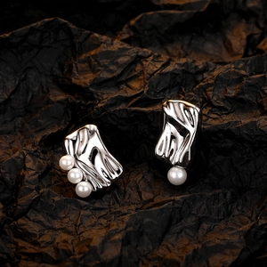 Elegant silver irregular square metal studs with white pearls on a dark textured background