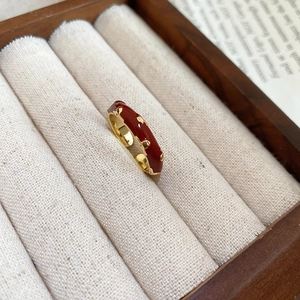 Detailed view of a vintage 14k gold-plated ring with red enamel and golden bead accents