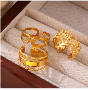 Detailed view of three assorted 18K gold-plated hollow geometric and link rings in a box
