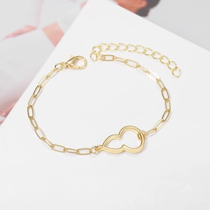 Close-up of gold paperclip chain bracelet with hollow heart design and lobster clasp
