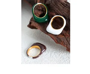 Detail of colorful enamel stacked rings on wood, minimalist 18k gold-plated jewelry design
