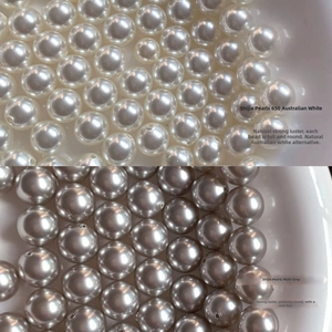 Detail comparing polished Australian white pearls and silvery grey pearls earrings