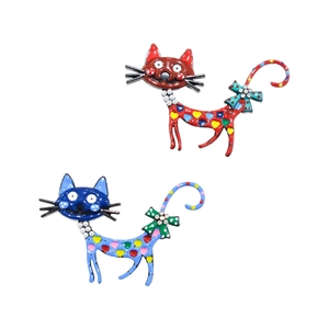 Détail de broches chat en émail avec pois et petits accents de perles sur le nœud