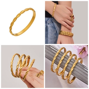 Detail of twisted 18k gold plated stainless steel bangles in a stylish four-way layout