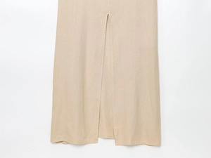 Détail d'une robe midi en mélange de lin avec ourlet fendu sur le côté en couleur beige