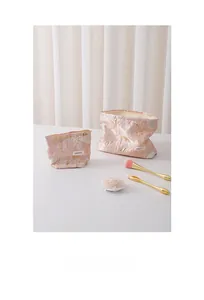 Detail of two pink floral jacquard cosmetic bags in large and small sizes with logo label