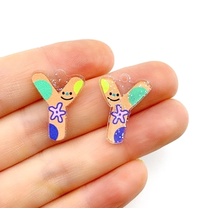 Macro detail of acrylic letter Y charm with colorful patterns and smiling face design