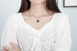 Close-up of Sagittarius zodiac necklace with green malachite pendant on gold chain