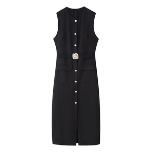 Detail of elegant black midi dress featuring gold waist buttons and tailored sleeveless cut