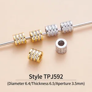 Macro detail of cylindrical zircon spacer beads with 18K gold and platinum plating
