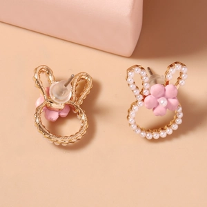 Detail of rose gold rabbit stud earrings with white pearls and pink floral accent