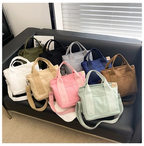 Collection of colorful canvas tote bags with adjustable straps on a stylish leather sofa