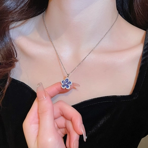 Detailed view of silver necklace featuring a blue five-petal flower pendant with zircon