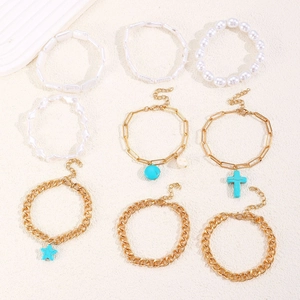 Collection of bohemian turquoise charms and white beaded bracelets on stone surface