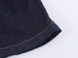 Dettaglio del tessuto denim blu scuro con cuciture arancioni a contrasto nitido