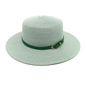 Détail d'un chapeau en paille vert menthe avec tissage fin, ceinture et boucle dorée