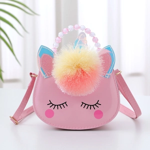 Detailed view of pink unicorn handbag featuring beaded handle and soft pompom decoration