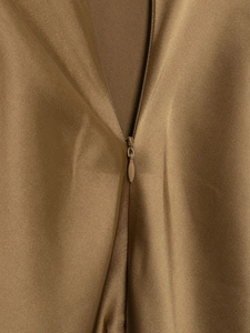 Close-up detail of khaki satin fabric with smooth invisible zipper on backless dress