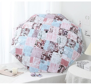 Detail of vintage newspaper collage print on umbrella featuring pink and blue accents