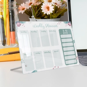 Detail shot of a transparent acrylic weekly planner board on a tidy office desktop