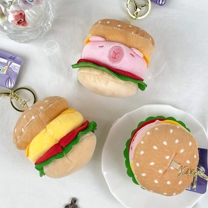 Cute hamburger animal plush keychain charms displayed on white fabric with creative sketches