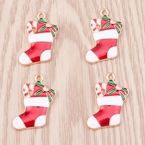 Detail of red Christmas stocking pendants with green bows and golden edges for DIY jewelry