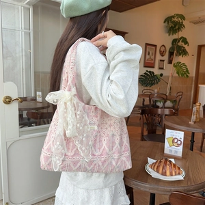 Detailed close-up of pink lace tote bag with floral lining and large bow accent