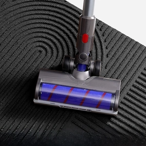 Close-up of vacuum cleaner brush head cleaning a durable non-slip black entrance mat