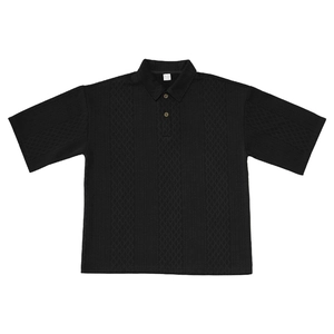Detail of black men's knit polo shirt showing intricate diamond textured jacquard fabric
