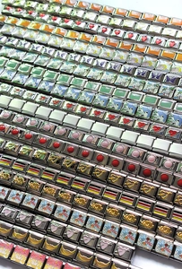 Macro view of modular stainless steel Italian charms with colorful enamel designs