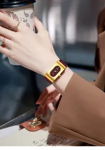 Vintage gold rectangular quartz watch with deep burgundy leather strap on model wrist