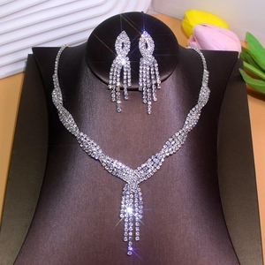 Detail of silver V-shaped fringe necklace and matching long tassel earrings with rhinestones