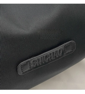 Close-up of durable black fabric texture and embossed leather logo tag on trendy bag