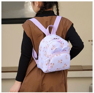 Side view of purple kids backpack with teddy bear prints on a young child model