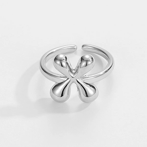 Makro-Detail eines silbernen, verstellbaren Rings mit poliertem vierblättrigem Kleeblatt