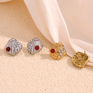 Detail of scallop shell earrings with gold plating, white crystals and red bead accents