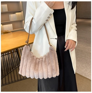 Dettaglio della texture di una borsa a tracolla in peluche rosa antico a righe