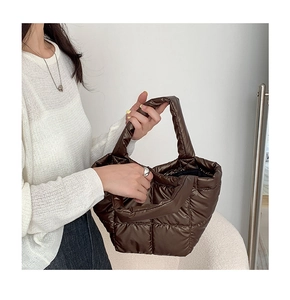 Detail of dark brown quilted puffer tote bag with soft padded handles and nylon finish