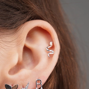 Silver snake-shaped ear studs for women crafted in a sleek minimalist jewelry style