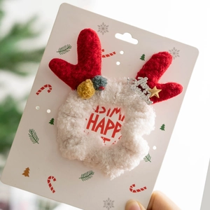 Close-up of white plush Christmas reindeer antler headband with festive star ornaments