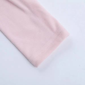 Dettaglio del tessuto a maglia rosa che mostra la trama fine e le rifiniture a doppia cucitura