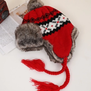 Close-up of red knitted trapper hat with snowflake patterns and grey faux fur lining