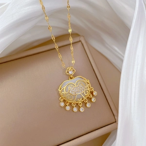 Detail of gold tassel lock necklace with white mother of pearl and crystals on silk