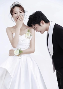 Detail of white artificial rose boutonniere and wrist corsage set on wedding attire
