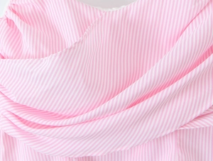 Close-up of pink and white striped fabric showing pleated texture and soft draped detail